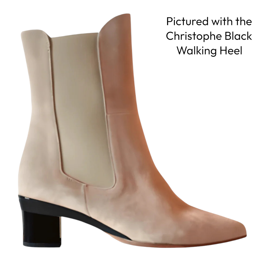 Pair of beige ankle boots with a black heel on a white background