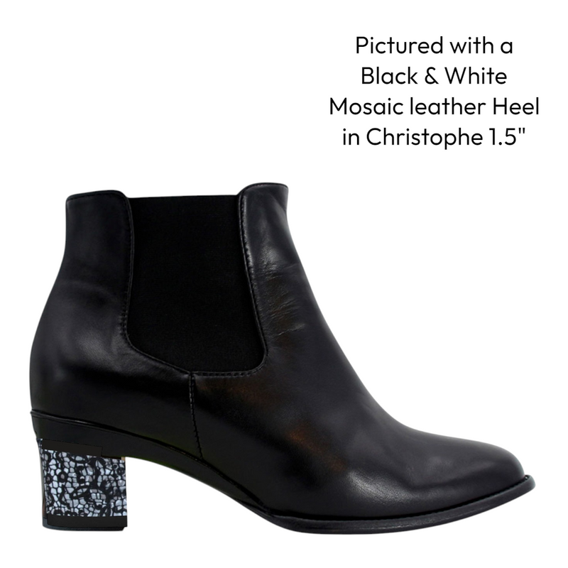Black leather Chelsea ankle boot with a low decorative heel on a white background